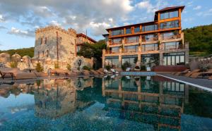 un edificio con piscina di fronte a un edificio di Chateau Mere a Telavi