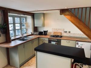 a kitchen with a sink and a counter top at Hideaway cottage in Bovey Tracey