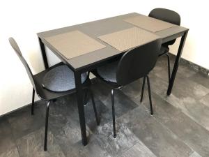 a black table and two chairs sitting around it at Ferienwohnung "am Ochsentor" in Andernach