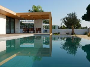 una piscina en una villa con una casa en Casa das Pérgolas en Comporta