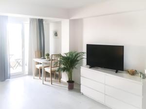 uma sala de estar com uma televisão de ecrã plano num armário branco em Airport Residence - Across from Otopeni Airport em Otopeni