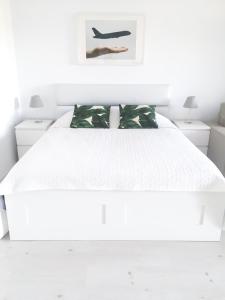 a white bedroom with a white bed and two night stands at Airport Residence - Across from Otopeni Airport in Otopeni