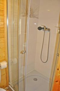 a shower with a glass door in a bathroom at Acapulco Domki Radków in Radków