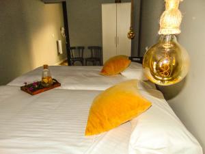 sypialnia z białym łóżkiem z żółtymi poduszkami w obiekcie Balneario Aguas de Villaharta w mieście Villaharta