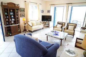 un soggiorno con divano blu e sedie di Villa Marika a Vathi