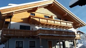 una casa con un balcón de madera en la parte superior en Oberrollerhof, en Virgen