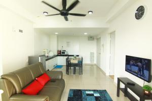 een woonkamer met een bank en een plafondventilator bij 10:39 Studio @ D'Perdana Sri Cemerlang in Kota Bharu