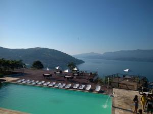 a pool with lounge chairs and a view of the water at Flat Angra Portogalo in Angra dos Reis