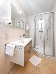 a white bathroom with a sink and a shower at Hotel-Restaurant Lampenhäusl in Fusch an der Glocknerstraße