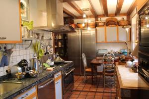 a kitchen with stainless steel appliances and a table at Chambres d'hôtes La Brillève in Lamotte-Beuvron