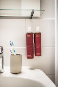 dos botellas de odorizantes se sientan en un lavabo en un baño en Urbn Dreams III en Berlín