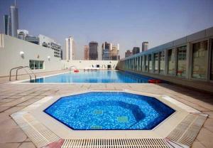 a large blue swimming pool on the side of a building at Hometown Apartments - Waterfront 1 Bedroom apartment in Westside Marina in Dubai