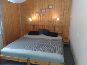 um quarto com uma cama numa parede de madeira em Na Polesí em Žlutice