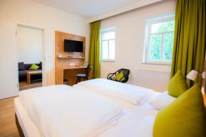 a hotel room with two beds and a television at Landhaus Rössle in Schwäbisch Hall +51 photos