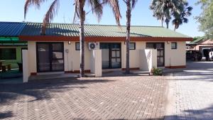 a building with palm trees in front of it at RY Courtyard in Oshakati