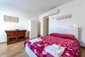 a bedroom with a large bed with a pink bedspread at Il Giardino Dell'Argano Rosso in Rome