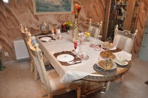 a dining room table with a white table cloth and chairs at Bed & Breakfast Rita in Delfzijl