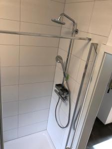 a shower with a hose hanging on a wall at Ferienwohnung "An der Stadtmauer" in Andernach