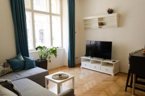 a living room with a couch and a flat screen tv at Oltec Apartment Brno in Brno