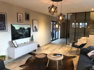 a living room with a couch and a table at Gîte Wellness Le Six H in Andolsheim