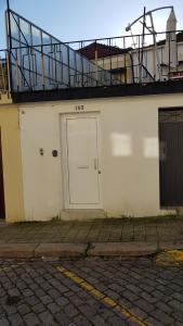 ポルトにあるOporto Cozy Studioの白いドアとバルコニー付きの白い建物