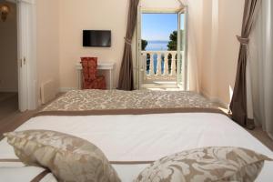 a bedroom with a large bed and a balcony at Luxury Rooms Villa Jadranka in Makarska +23 photos