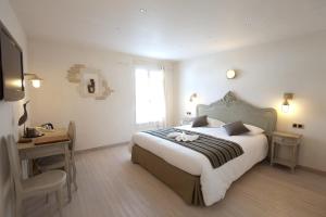 a bedroom with a bed and a desk and a window at Chambre d'hôtes Hôte des Portes Île de Ré in Les Portes