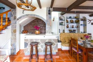 a kitchen with a stone fireplace with a table and stools at Hacienda El Molino in El Bosque
