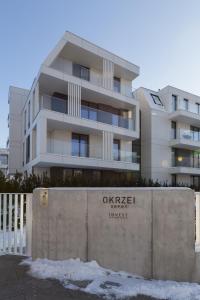a building in front of a concrete wall with the words oxzsche research at Apartament przy sopockiej plaży in Sopot