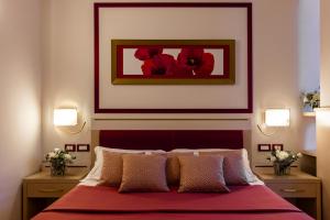 a bedroom with a bed with a red bedspread at Kora Park Resort in Formia