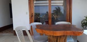 a wooden table and chairs in a room at Casa Los Delfines in Puerto Villamil