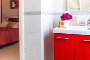 a bathroom with a red cabinet and a sink at Kora Park Resort in Formia