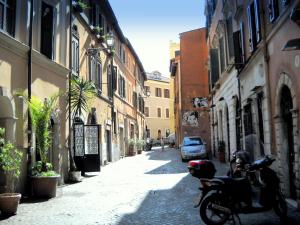 una moto parcheggiata in una strada in un vicolo di Paola's Apartment in the heart of Trastevere, Roma a Roma
