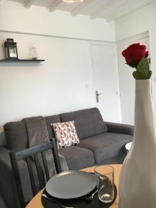 a living room with a couch and a table with a vase at SWEET APARTMENT CARRIERES - 1 chambre - 4 Pers - Wifi in Carrières-sur-Seine