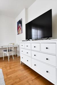 una cassettiera bianca con una TV a schermo piatto sopra di Haus Vollmeier a Debant Altre 10 foto