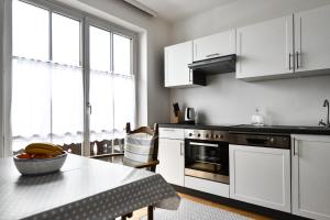 una cucina con mobili bianchi e un tavolo con una fruttiera di Haus Vollmeier a Debant