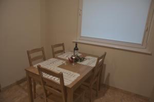 a dining room table with a bottle of wine and chairs at Apartament Joanna in Świnoujście