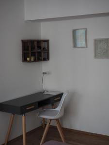 einen schwarzen Schreibtisch mit einem weißen Stuhl neben einer Wand in der Unterkunft 41 Reichsstraße in Düsseldorf