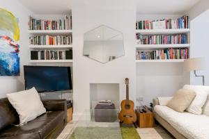 een woonkamer met een bank en een gitaar bij Tadmor Townhouse in Londen