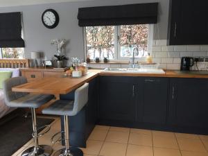 een keuken met een houten tafel en een wastafel bij Summer House, Glassonby in Penrith