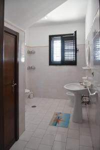 a white bathroom with a sink and a toilet at Villa Mary in Torre Lapillo +18 photos