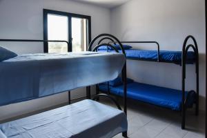 a room with three bunk beds and a window at Villa Mary in Torre Lapillo