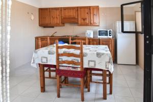 a kitchen with a table with chairs and a refrigerator at Villa Mary in Torre Lapillo