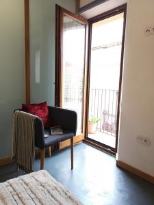 sala de estar con silla y ventana en Apartamentos 14DeSande, en Cáceres