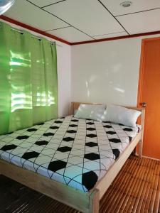 een slaapkamer met een bed met een zwart-wit dekbed bij BFF Backpacker's Inn in San Vicente