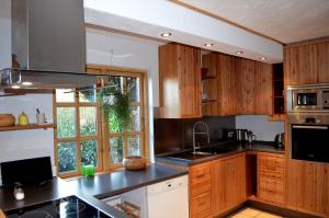 a kitchen with wooden cabinets and a large window at Holmgård in Süderholm