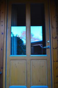 uma porta de madeira com duas janelas em Holmgård em Süderholm