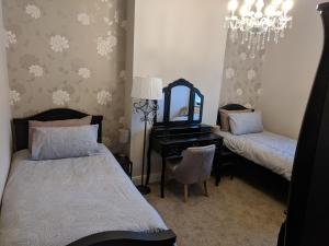 a bedroom with two beds and a mirror and a desk at Lion House Bed & Breakfast with Restaurant in Combe Martin
