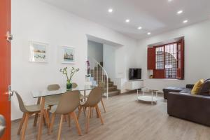 sala de estar con mesa, sillas y sofá en Casa de la Moneda - Center Luxury Duplex en Sevilla