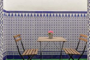 due sedie e un tavolo con una pianta in vaso di Casa de la Moneda - Center Luxury Duplex a Siviglia